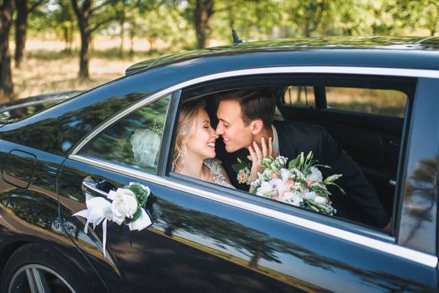 Bride and groom sitting in a decorated luxury car, symbolizing wedding car service