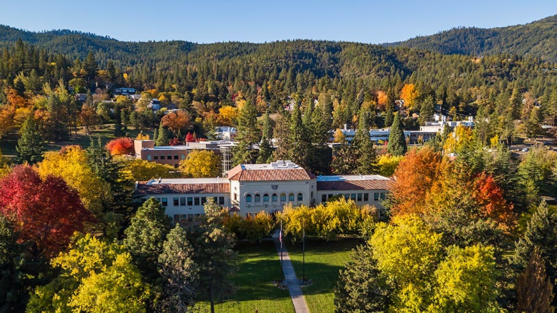 A historic estate nestled among trees and colorful autumn foliage, providing a peaceful and scenic setting.